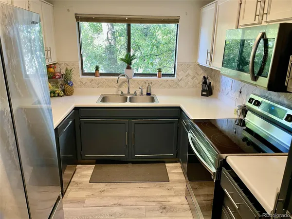 a kitchen with stainless steel appliances a sink stove and a refrigerator