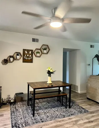 a living room with a table and paintings on the wall