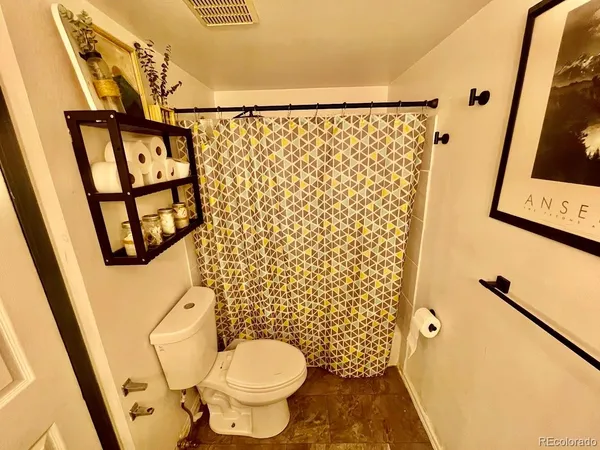 a bathroom with a toilet and a shower curtain