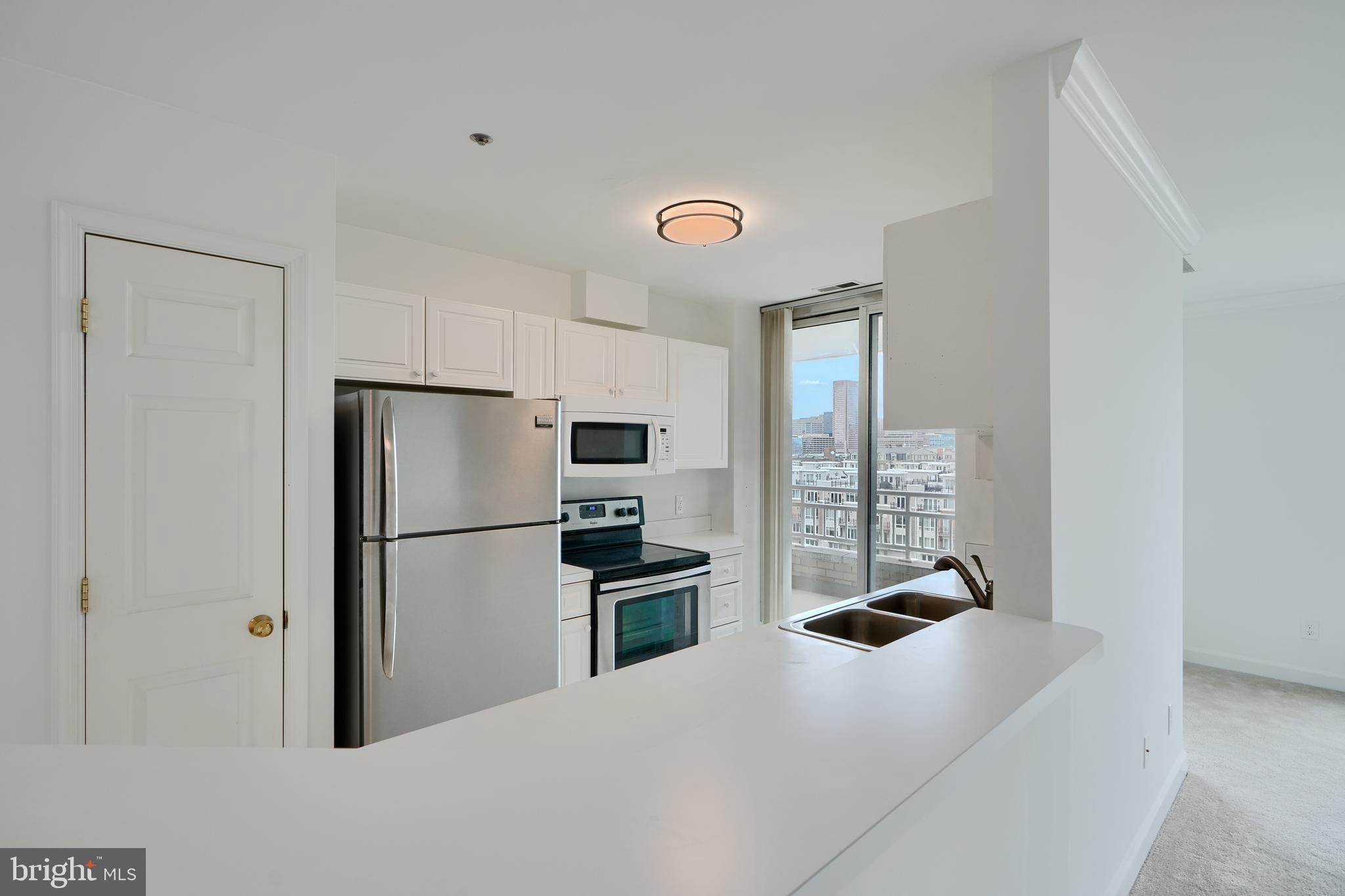 100 Harborview Drive, Unit 609 Baltimore, MD 21230 - Photo 4 of 45 a kitchen with a refrigerator a stove top oven a refrigerator and a window