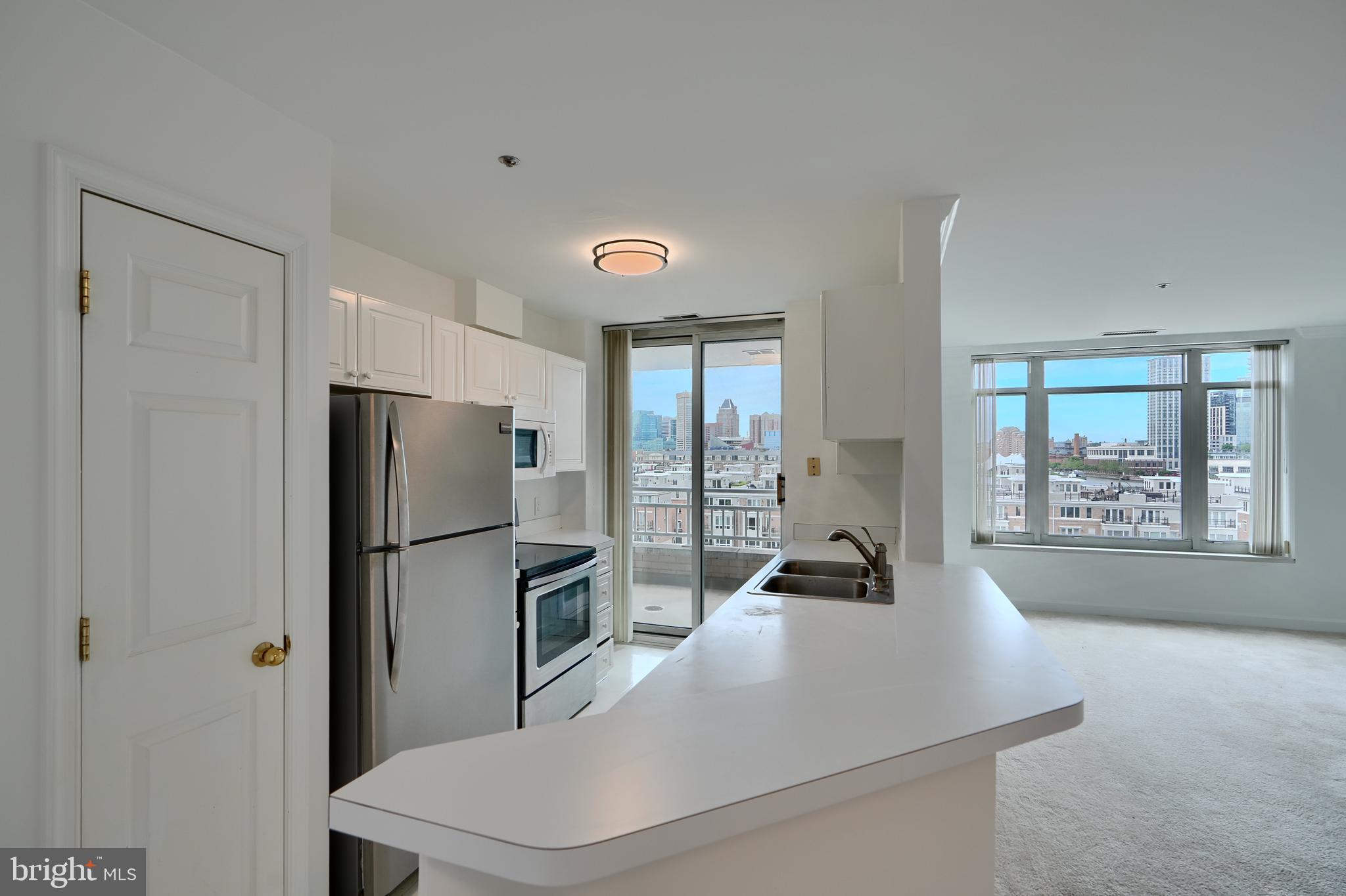 100 Harborview Drive, Unit 609 Baltimore, MD 21230 - Photo 5 of 45 a kitchen with stainless steel appliances a refrigerator and a large window