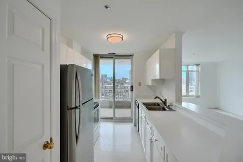 a kitchen with stainless steel appliances a refrigerator and a large window