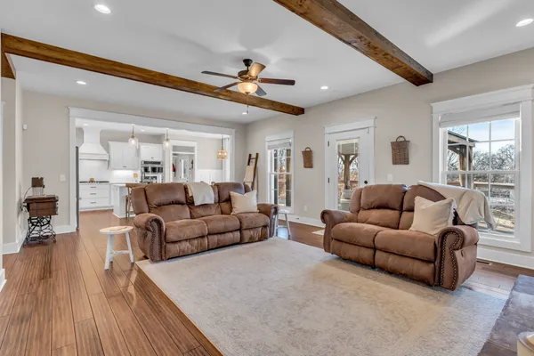 a kitchen with stainless steel appliances kitchen island granite countertop a table chairs and a refrigerator