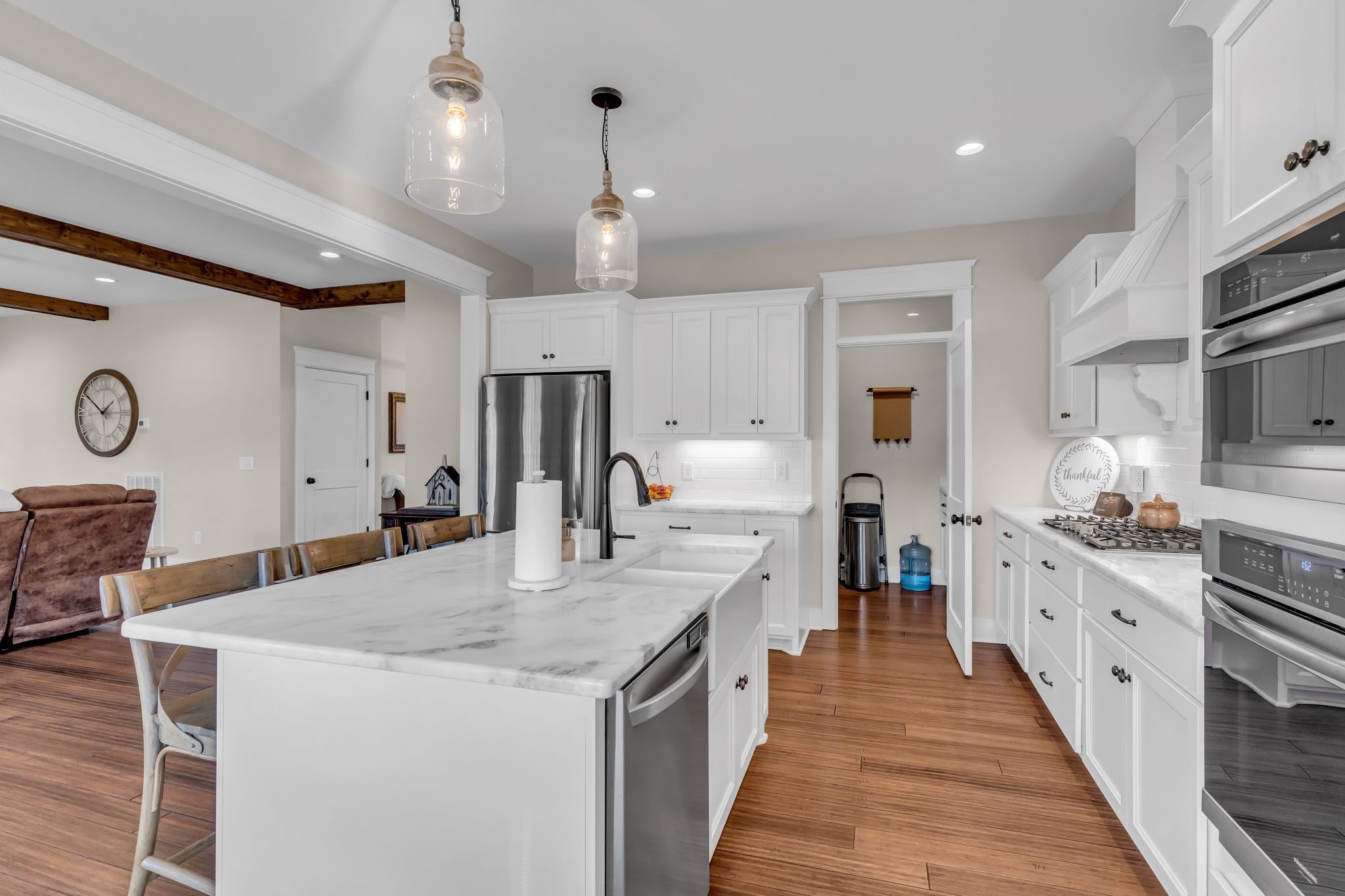 5574 Dowlen Road Cedar Hill, TN 37032 - Photo 20 of 59 a large kitchen with stainless steel appliances kitchen island granite countertop a table chairs in it and a wooden floors