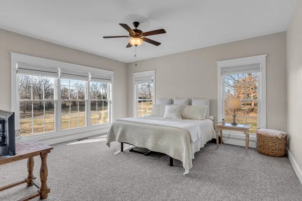 a bedroom with a bed and a large window