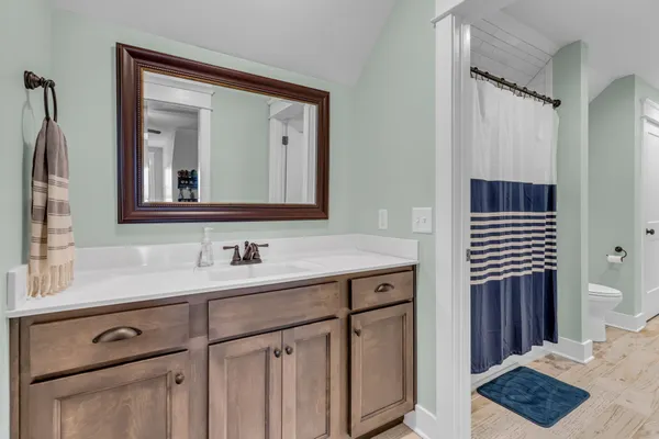 a bathroom with a toilet sink and mirror