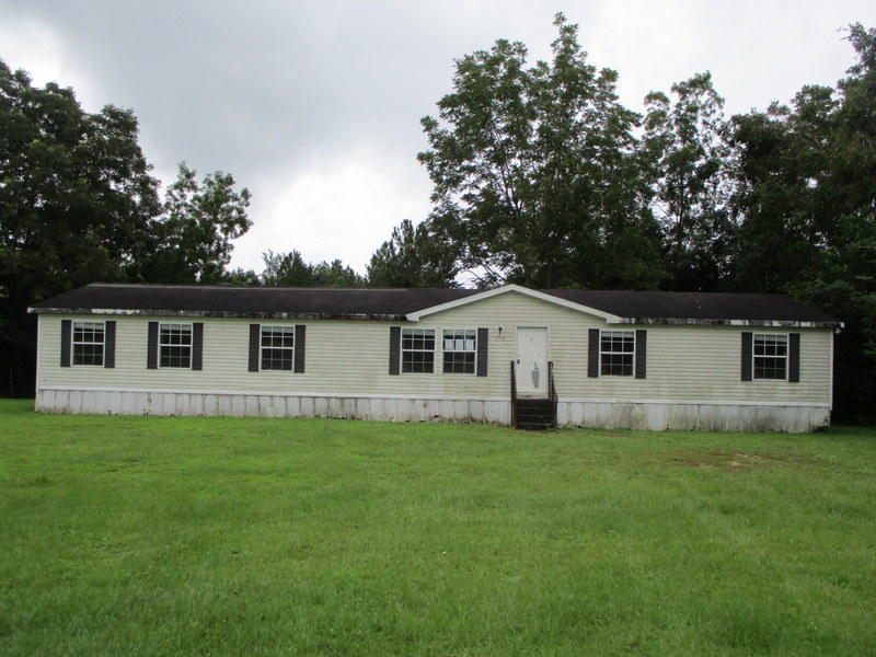 1901 Sexton Road DeFuniak Springs, FL 32433 - Photo 1 of 16 a house that is sitting in the grass with large trees and plants