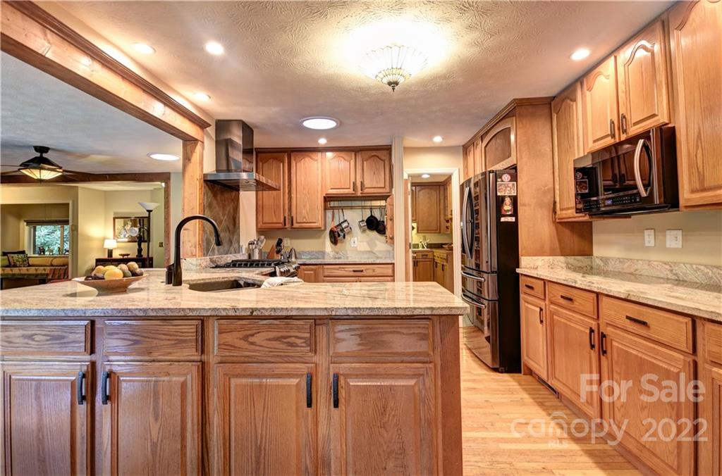 11 Echo Lake Drive Fairview, NC 28730 - Photo 22 of 48 a kitchen with stainless steel appliances granite countertop a sink refrigerator and cabinets