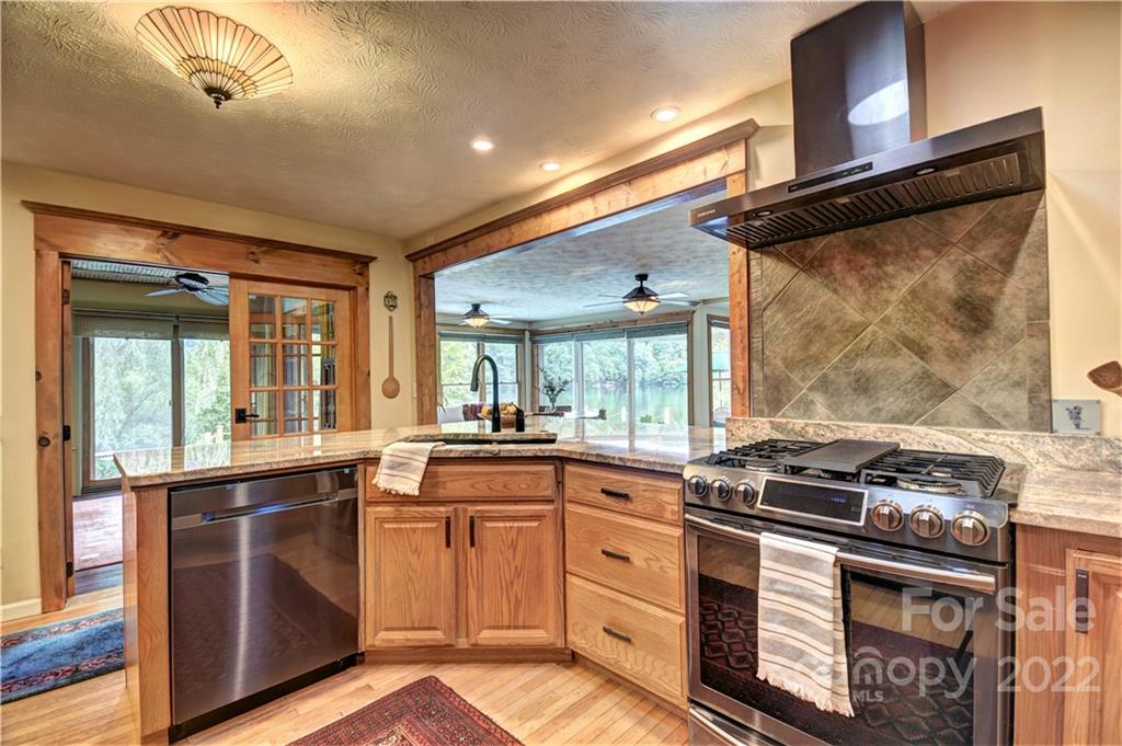 11 Echo Lake Drive Fairview, NC 28730 - Photo 23 of 48 a kitchen with stainless steel appliances granite countertop a stove a sink and a microwave