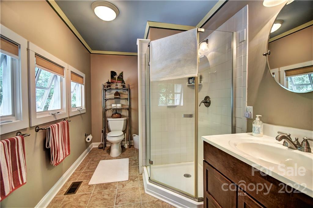 11 Echo Lake Drive Fairview, NC 28730 - Photo 48 of 48 a bathroom with a granite countertop sink a mirror and a shower