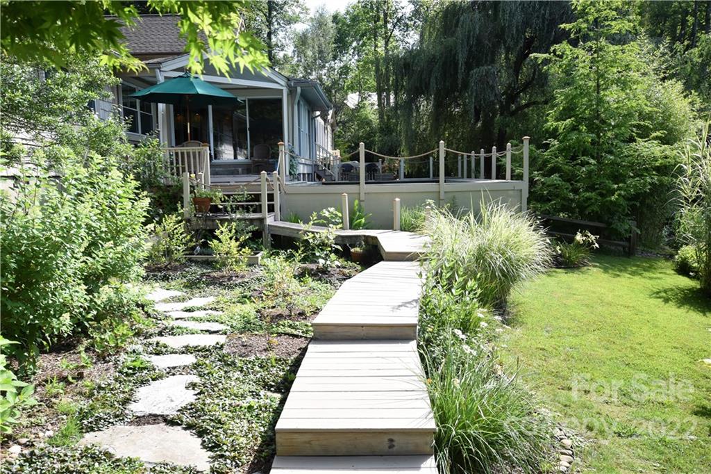 11 Echo Lake Drive Fairview, NC 28730 - Photo 6 of 48 a view of a backyard with table and chairs potted plants and large tree
