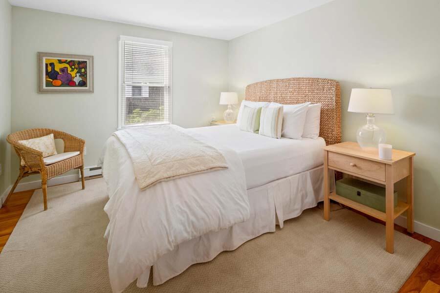 596 Shore Road, Unit 3 Truro, MA 02666 - Photo 12 of 37 a bedroom with a bed and a chair