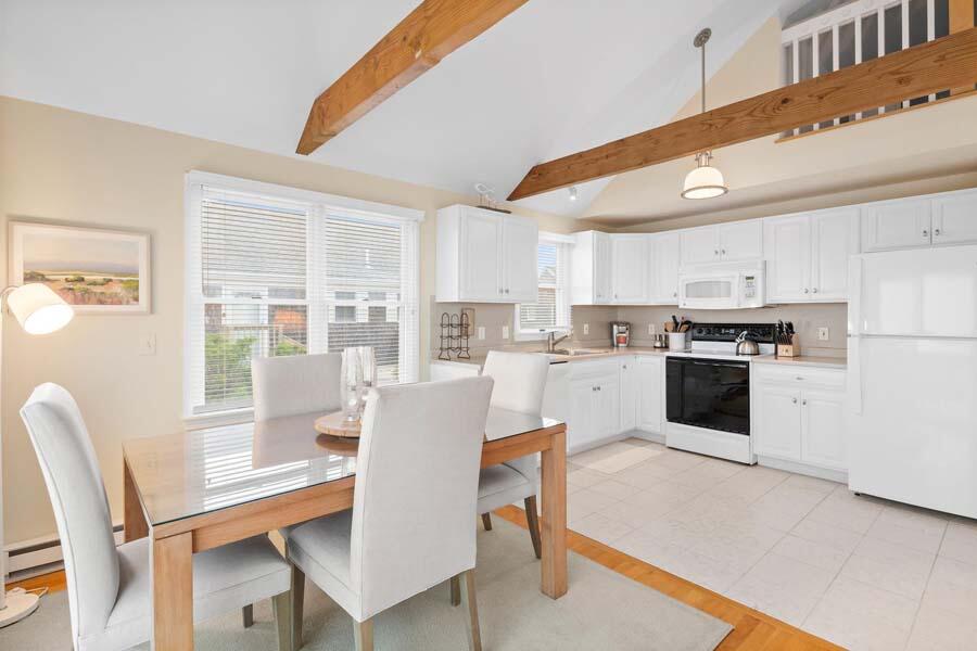 596 Shore Road, Unit 3 Truro, MA 02666 - Photo 6 of 37 a kitchen with stainless steel appliances granite countertop a stove a refrigerator a dining table and chairs