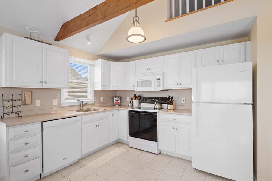 596 Shore Road, Unit 3 Truro, MA 02666 - Photo 7 of 37 a kitchen with white cabinets and white appliances