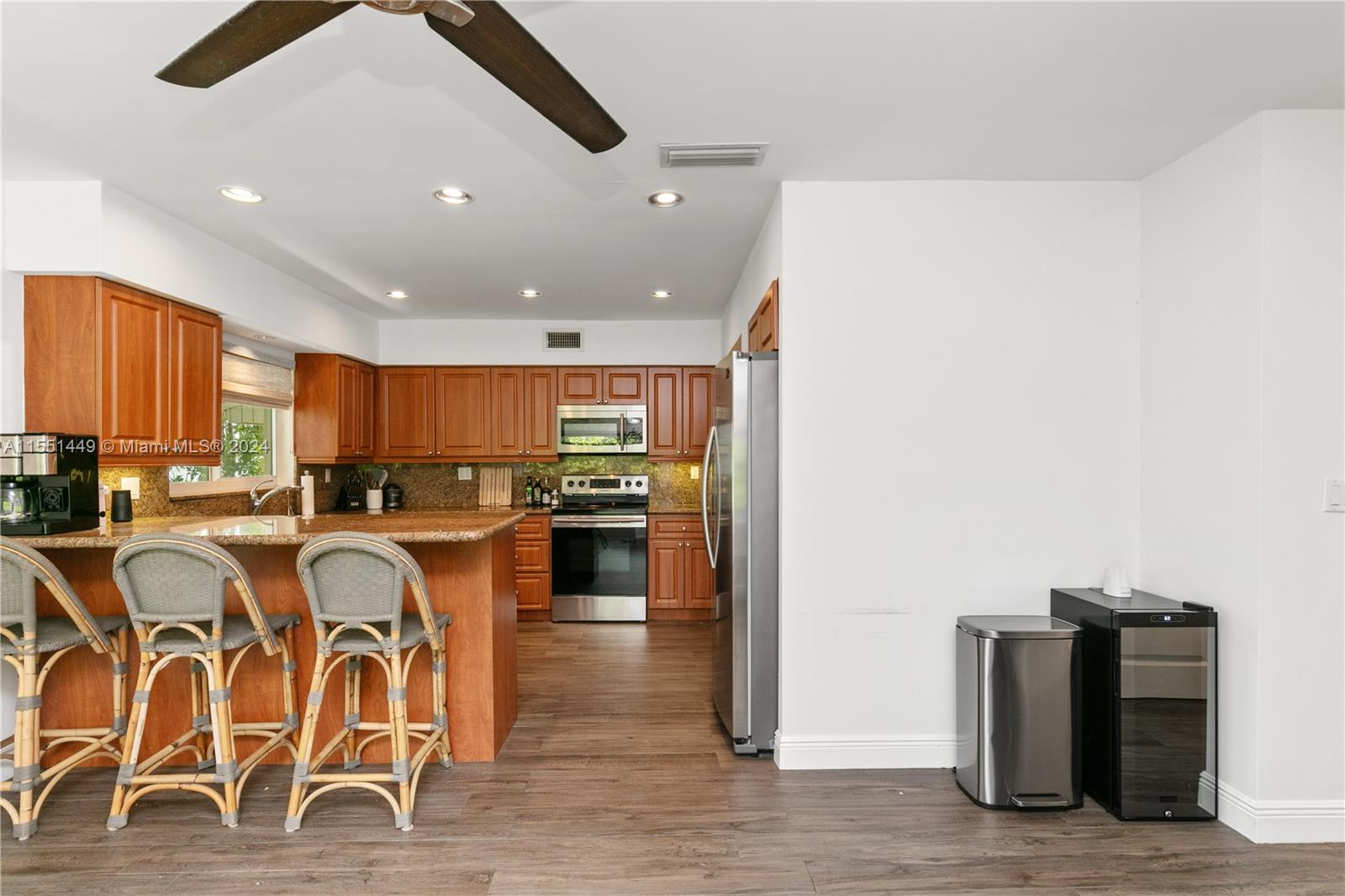 412 Ridgewood Road Key Biscayne, FL 33149 - Photo 27 of 47 a large kitchen with granite countertop a stove and white cabinets