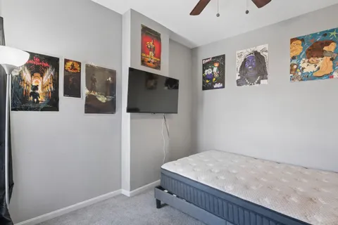 a bedroom with a bed and painting on the wall
