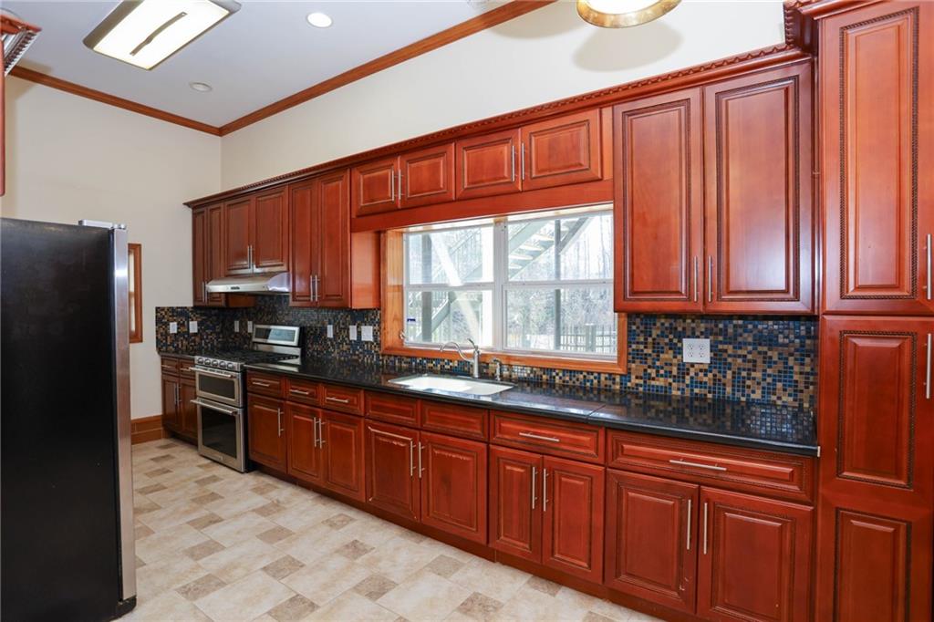 3602 Jones Mill Road Peachtree Corners, GA 30360 - Photo 6 of 35 a kitchen with stainless steel appliances granite countertop wooden cabinets a refrigerator and a sink