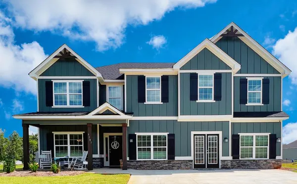 a front view of a house with lots of windows and plants