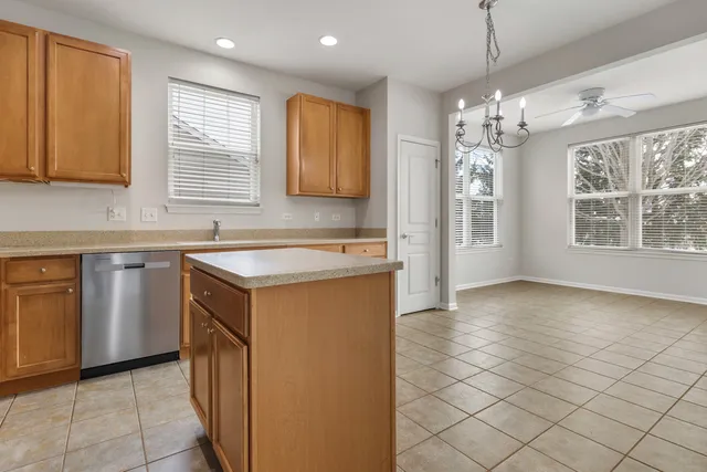 a kitchen with a sink a center island cabinets and a window