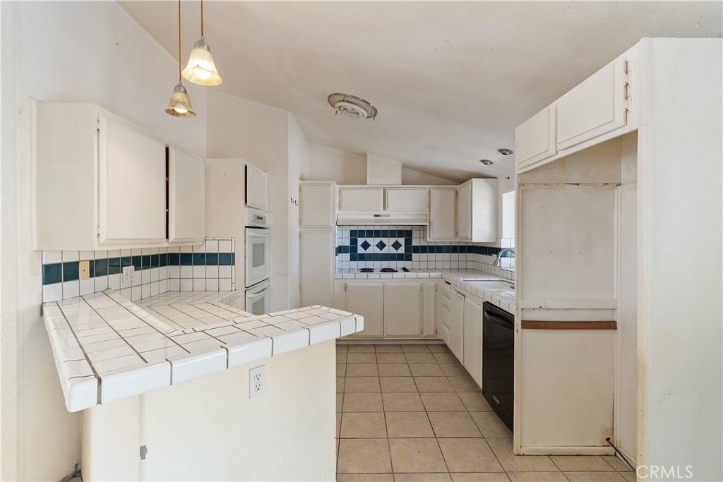 34881 Los Nogales Road Temecula, CA 92592 - Photo 26 of 50 Kitchen with tile counters, garden window, electric cooktop with vent.