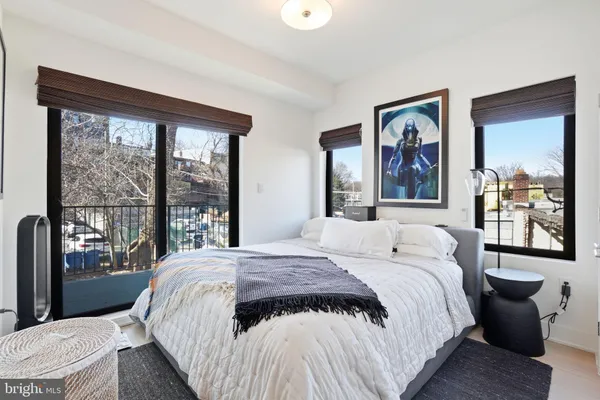a bedroom with a bed and a large window