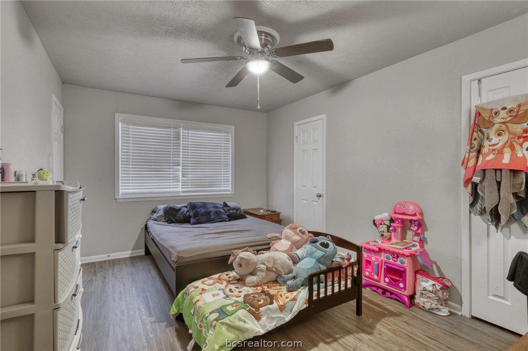 1908 Barak Lane, Unit 14 Bryan, TX 77802 - Photo 8 of 10 Bedroom with ceiling fan, light hardwood / wood-style flooring, and a textured ceiling