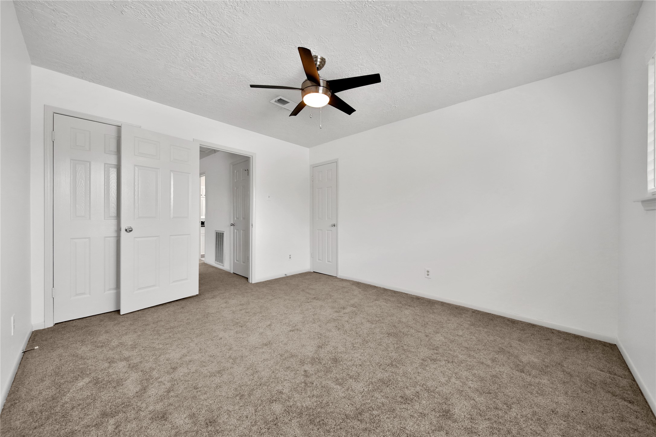 9411 Roos Road Houston, TX 77036 - Photo 33 of 41 an empty room with a ceiling fan and window