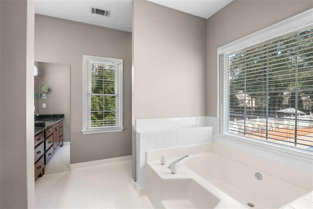 2678 North Bogan Road Northeast Buford, GA 30519 - Photo 18 of 52 a bathroom with a bathtub and a shower