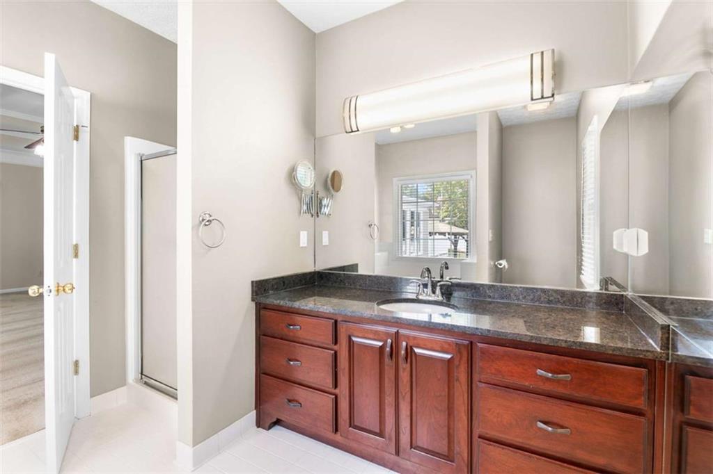 2678 North Bogan Road Northeast Buford, GA 30519 - Photo 19 of 52 a bathroom with a granite countertop sink and a mirror