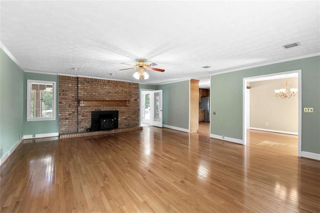 2678 North Bogan Road Northeast Buford, GA 30519 - Photo 46 of 52 a view of an empty room with wooden floor fireplace and a window