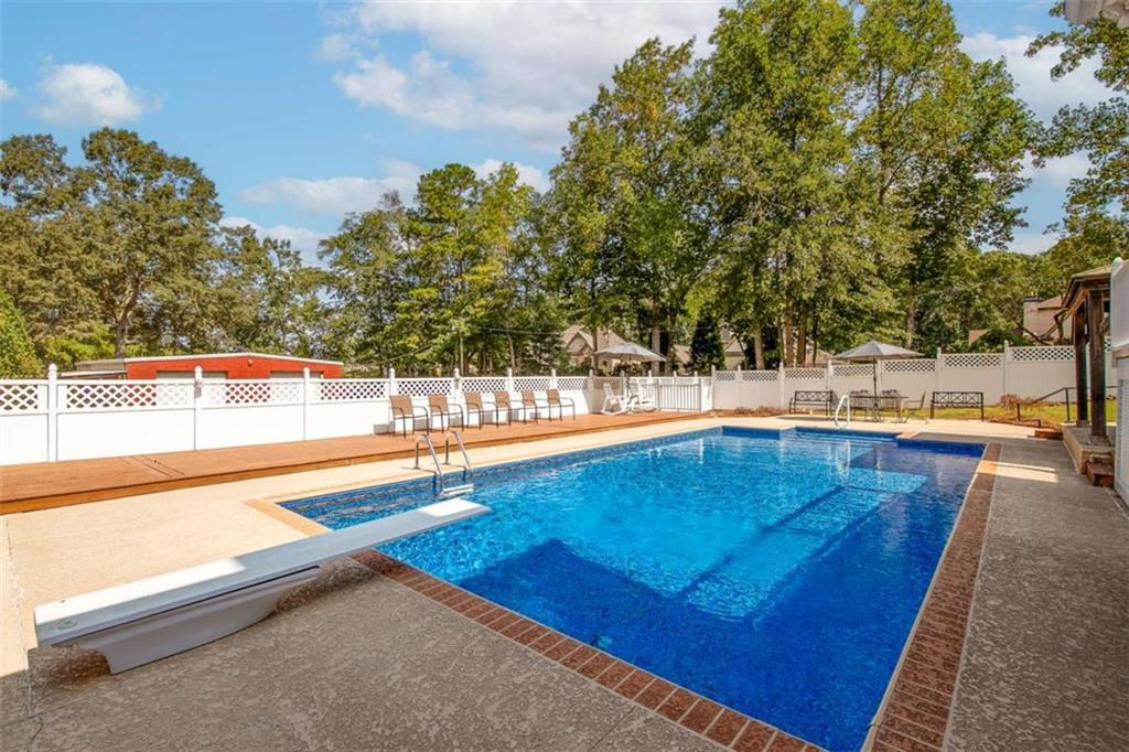 2678 North Bogan Road Northeast Buford, GA 30519 - Photo 6 of 52 a view of swimming pool with outdoor seating and trees in the background