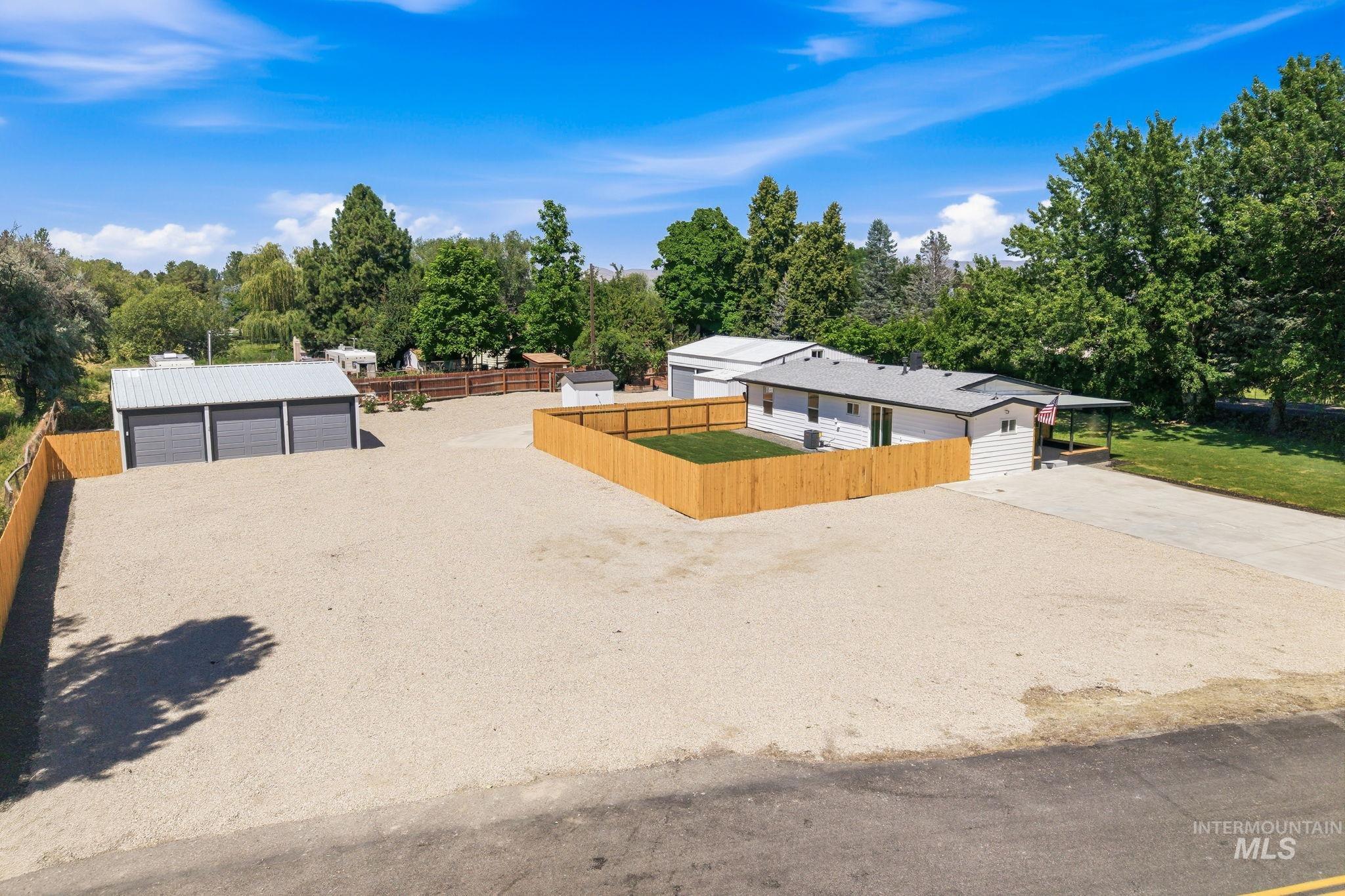 2152 Artesian Road Eagle, ID 83616 - Photo 37 of 50 Expansive gravel lot featuring a three-bay garage and a separate single-story residence