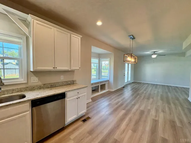 a kitchen with granite countertop white cabinets and white appliances