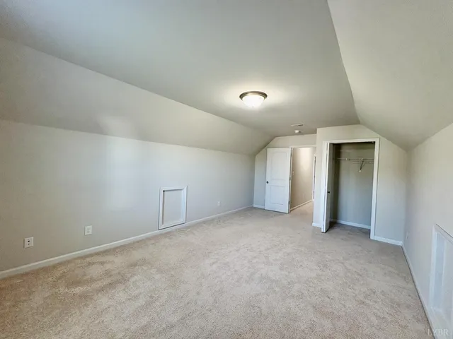 an empty room with closet and windows