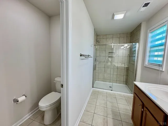 a bathroom with a granite countertop shower a toilet and a sink