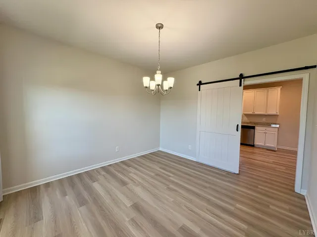 a view of a room with wooden floor staircase and a kitchen