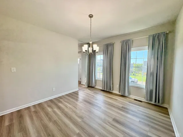 a view of a room with window wooden floor and front door