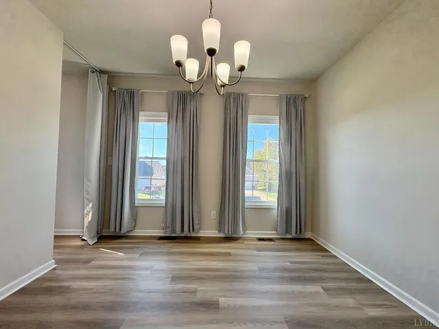 a view of a livingroom with a chandelier fan and windows