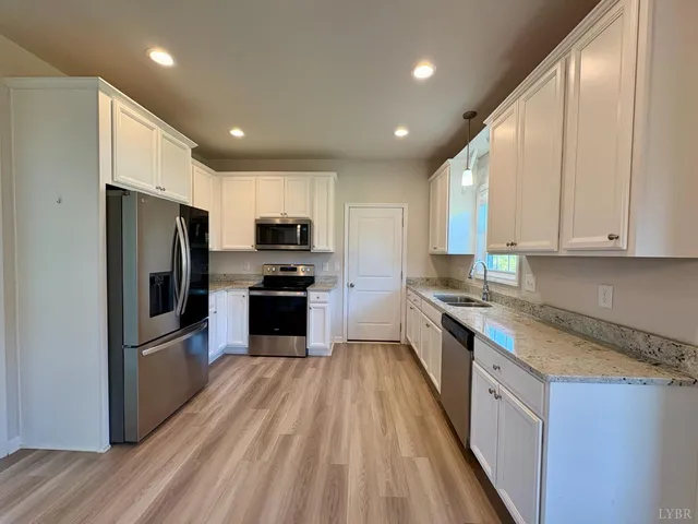a large kitchen with a large counter top stainless steel appliances and cabinets