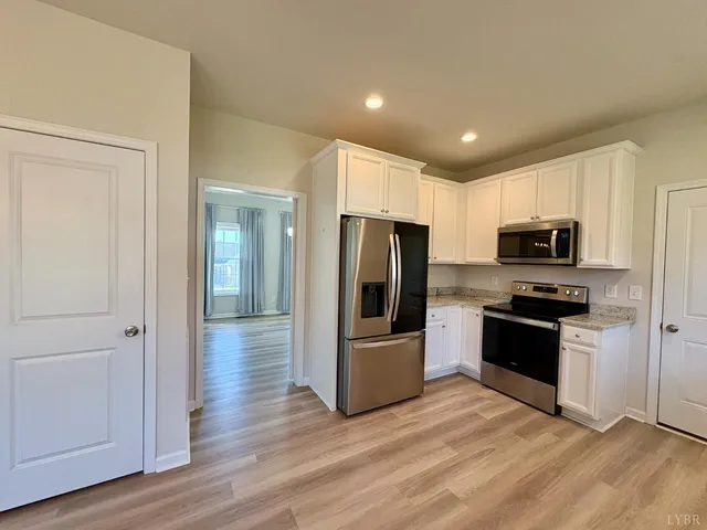 a kitchen with granite countertop a refrigerator and a stove top oven