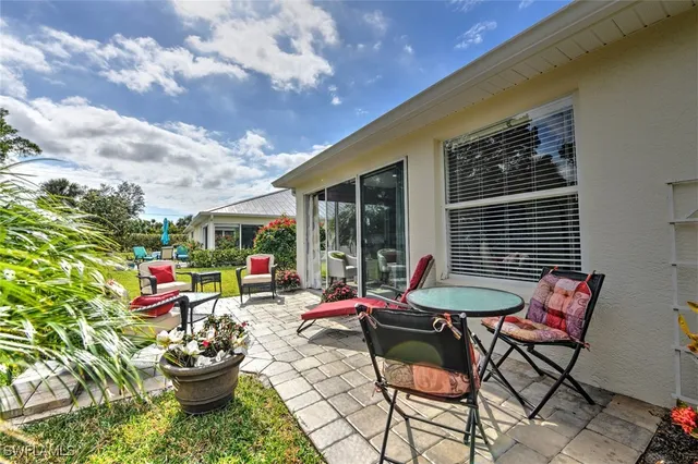 a backyard of a house with dining table and chairs