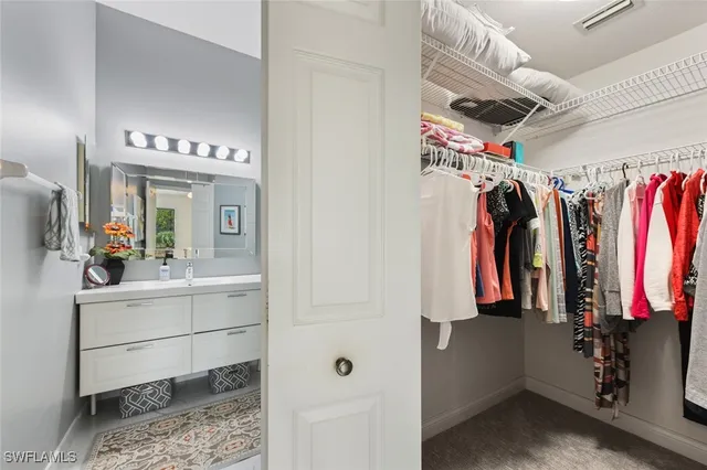 a view of walk in closet with clothes and shoes