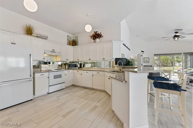 a kitchen with white cabinets and white appliances