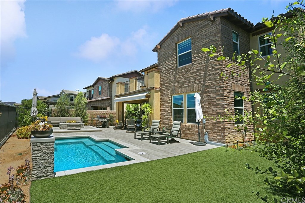 21 Baliza Road Rancho Mission Viejo, CA 92694 - Photo 1 of 1 Generous lot with salt water pool with spillway fountain, built-in stone fire pit, wood look tile liberally used, electric awning, outdoor shower, turf lawn and view sunning deck make staycations reality!