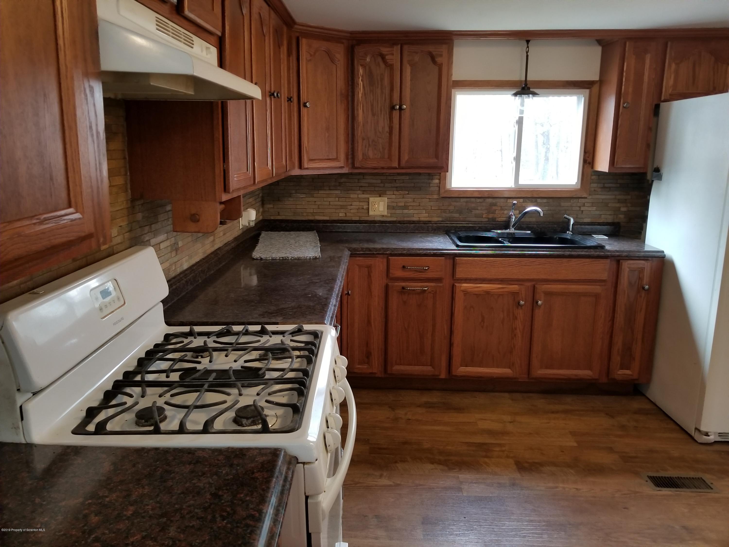 268 State Rte 4013 Little Meadows, PA 18830 - Photo 31 of 48 a kitchen with wooden cabinets and a stove top oven