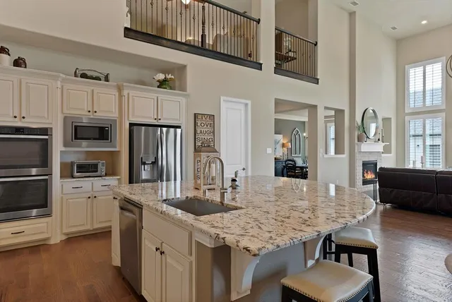 a kitchen with stainless steel appliances granite countertop a kitchen island a stove a table and chairs