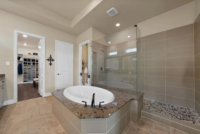 a bathroom with a granite countertop sink a shower and a mirror