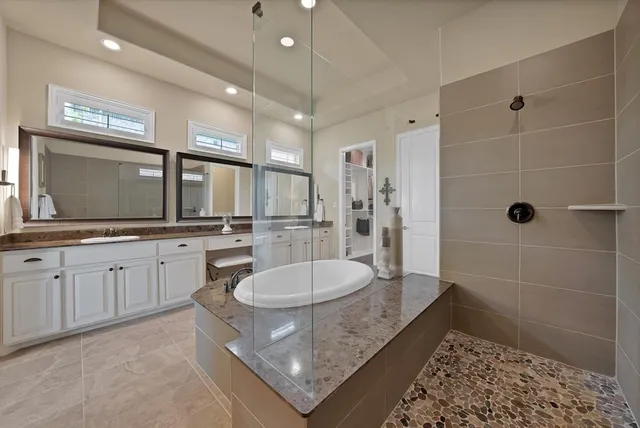 a bathroom with a granite countertop sink a mirror and a shower