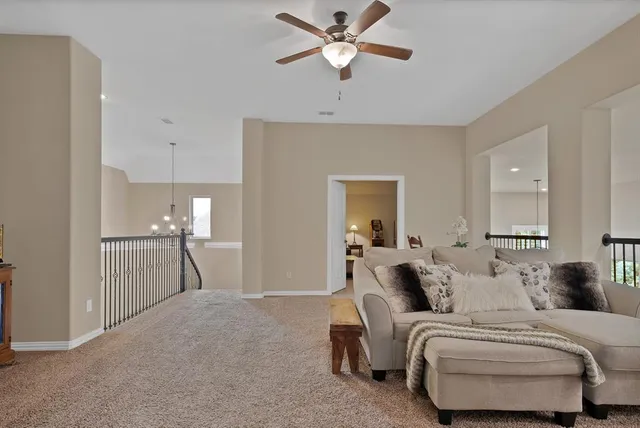 a living room with furniture a ceiling fan and a window