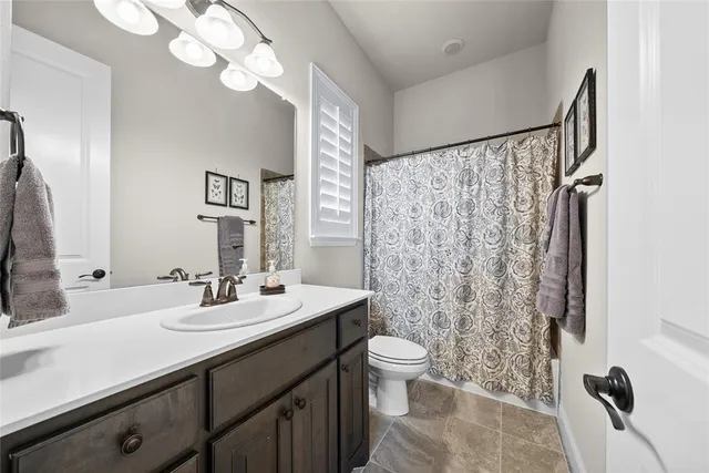 a bathroom with a double vanity sink mirror and toilet